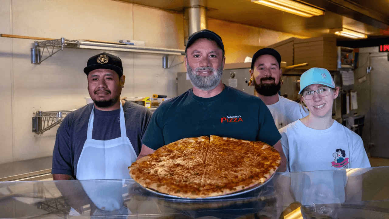Aj Pappalardo junto a su equipo de trabajo sosteniendo una pizza